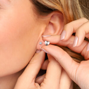 Model draagt MIA Jewellery oorbellen, stijlvolle en comfortabele opties voor gevoelige oren, eenvoudig te wisselen zonder de stud uit het oor te halen. Detail van model met MIA Jewellery oorbellen, benadrukt elegantie en draagcomfort, snel en eenvoudig te wisselen zonder de stud te verwijderen.