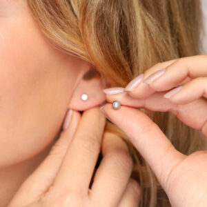 Model draagt MIA Jewellery oorbellen, stijlvolle en comfortabele opties voor gevoelige oren, eenvoudig te wisselen zonder de stud uit het oor te halen. Detail van model met MIA Jewellery oorbellen, benadrukt elegantie en draagcomfort, snel en eenvoudig te wisselen zonder de stud te verwijderen.